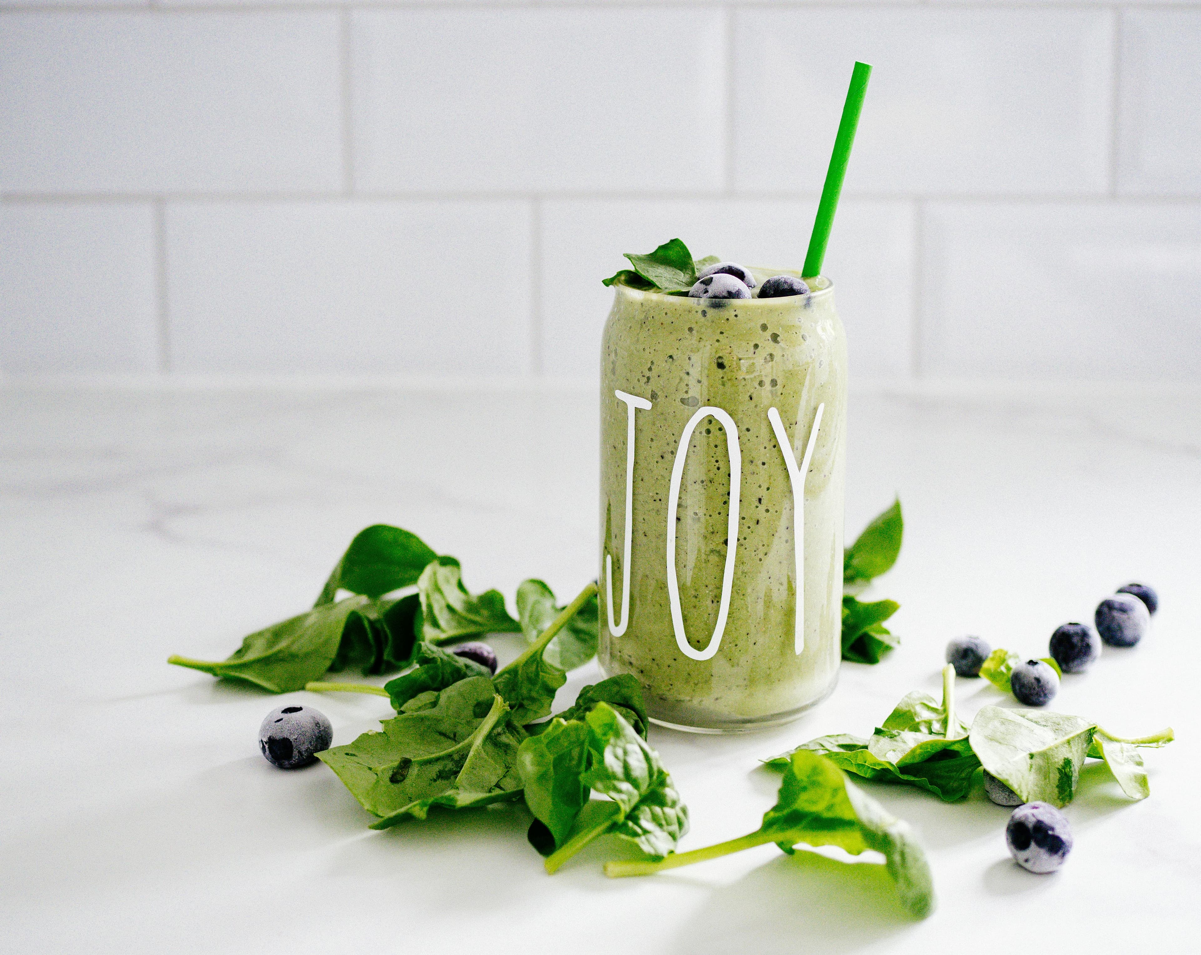Green smoothie with spinach and blueberries in a glass jar